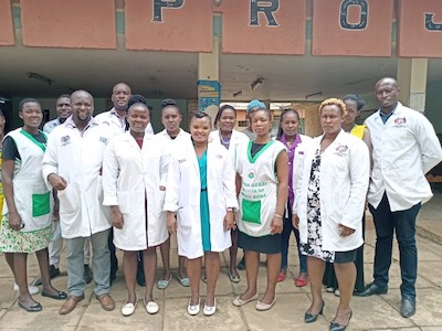 A group of people wearing white coats stand for a picture.