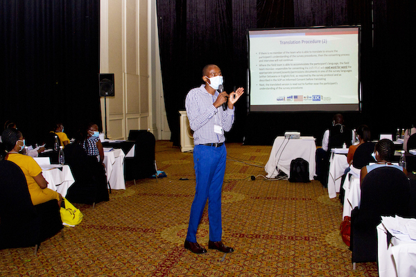 A person wearing blue pants speaks during a workshop. 